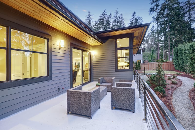 Beautiful backyard with a basket-woven sitting area and lash greens